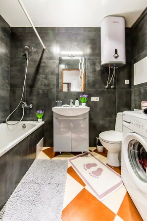 Een bad, een haardroger, handdoeken, toiletpapier