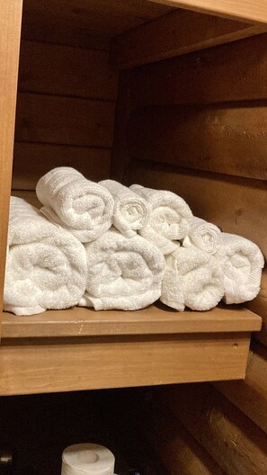 A wooden shelf with neatly folded white towels. - Bear Lodge: Pet-Friendly Tiny Cabin Near Cook Forest & Allegheny National Forest (Marienville)