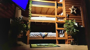 Dormitorio con literas, televisor, paredes de madera y decoración con estrellas.