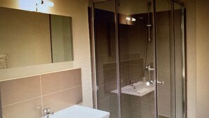 A modern bathroom with a glass-enclosed shower, a white sink, and a mirror above the sink. - Auberge Sainte Marguerite - "Anse Méjean" room (La Garde)
