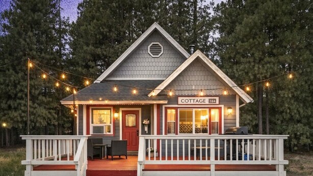 Una cabaña con un porche, un comedor y un letrero que dice 'COTTAGE 104'.