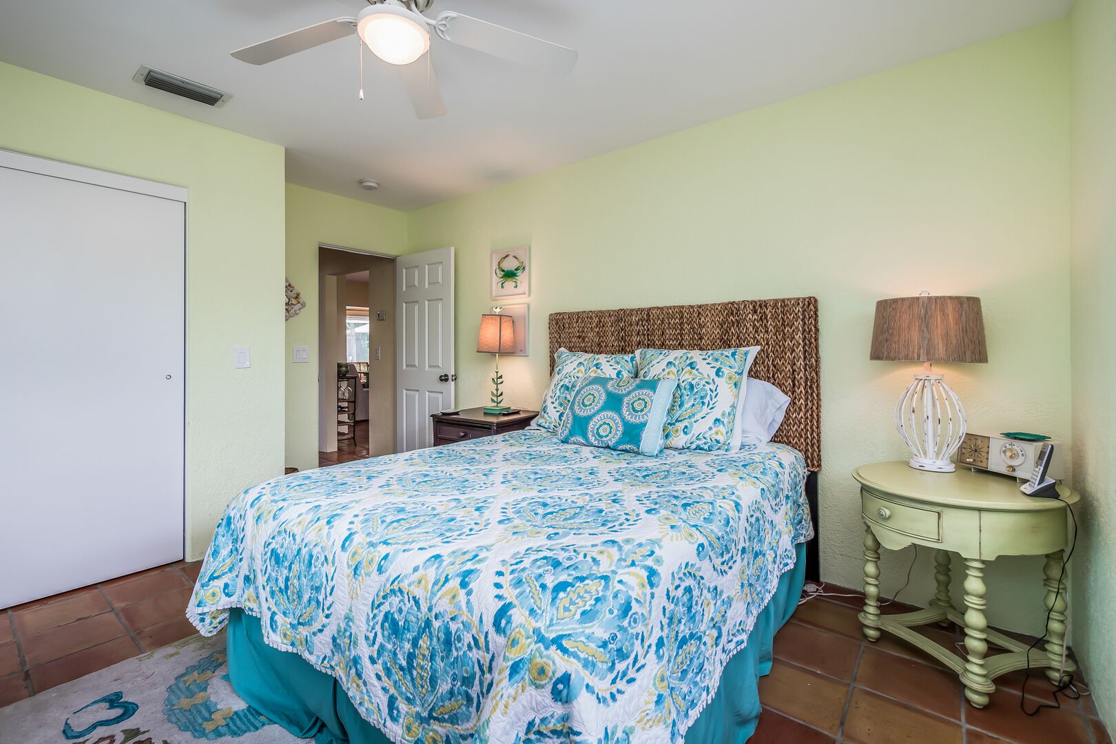 A bedroom with a bed, a nightstand, a lamp, and a ceiling fan.