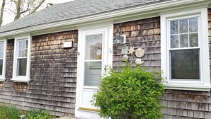 A house with a shingled exterior, white trim, and multiple windows.