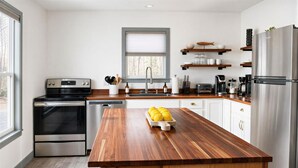 A modern kitchen with stainless steel appliances, a wooden island, and a window with blinds. - 4 Bedroom Lakehouse w/ Hot Tub, Firepit, & Game Room (Cadiz)