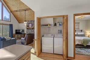 Cozy living space with a high ceiling, flat-screen TV, and comfortable seating area.