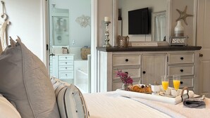 A bedroom with a bed, a dresser, a mirror, and a breakfast tray with orange juice glasses. - Serenity Waterfront 4BR w/ Private Dock, Heated Pool & Relaxing Hot Tub (Palm Coast)