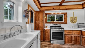 A kitchen with wooden cabinets, a stove, and a sink.
