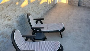 A rooftop terrace with two lounge chairs and a table, overlooking a cityscape and mountains. - Front line duplex penthouse with private pool! (Vera)
