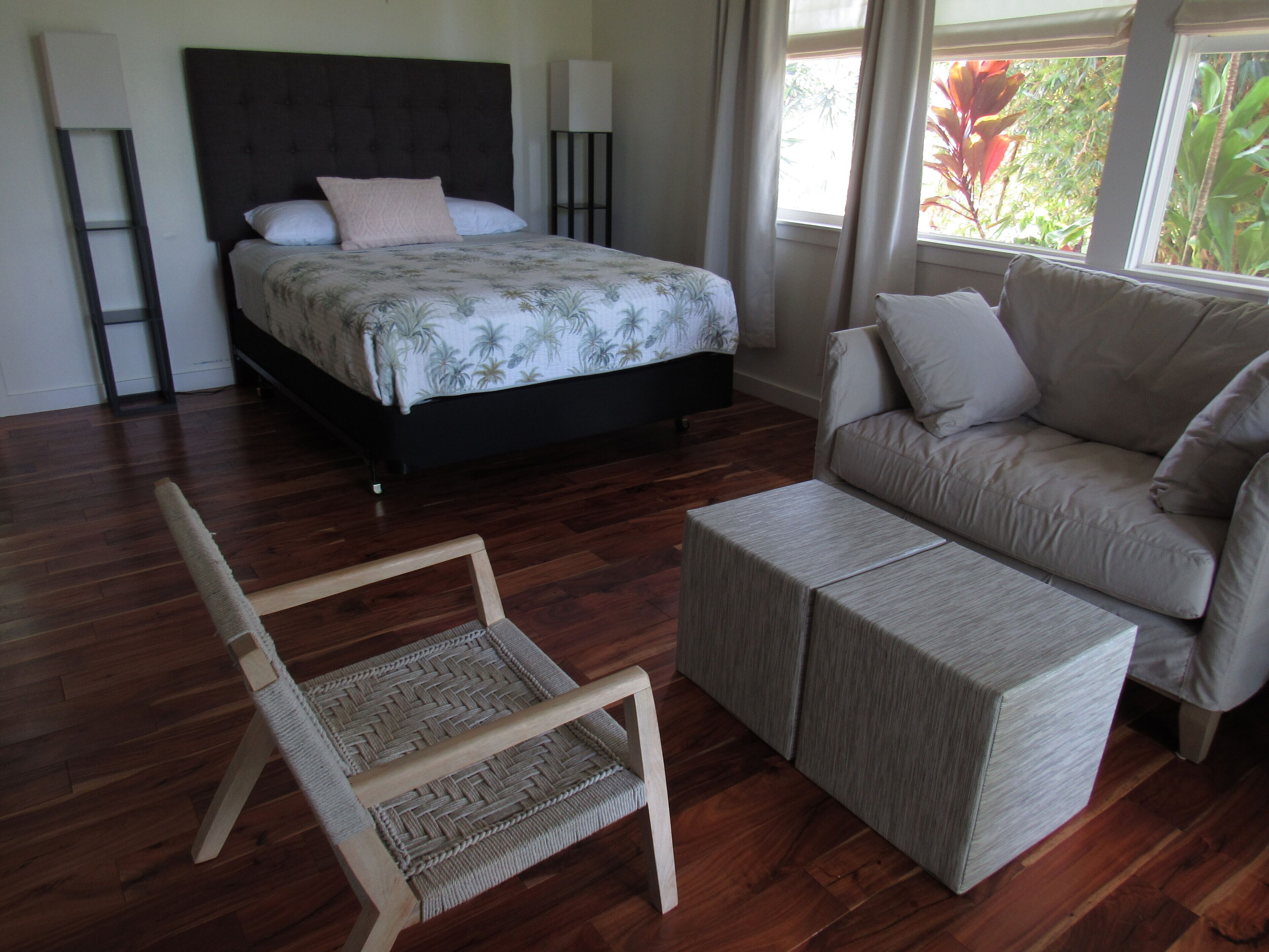 Une chambre à coucher avec un lit, un canapé, une chaise et une petite table.