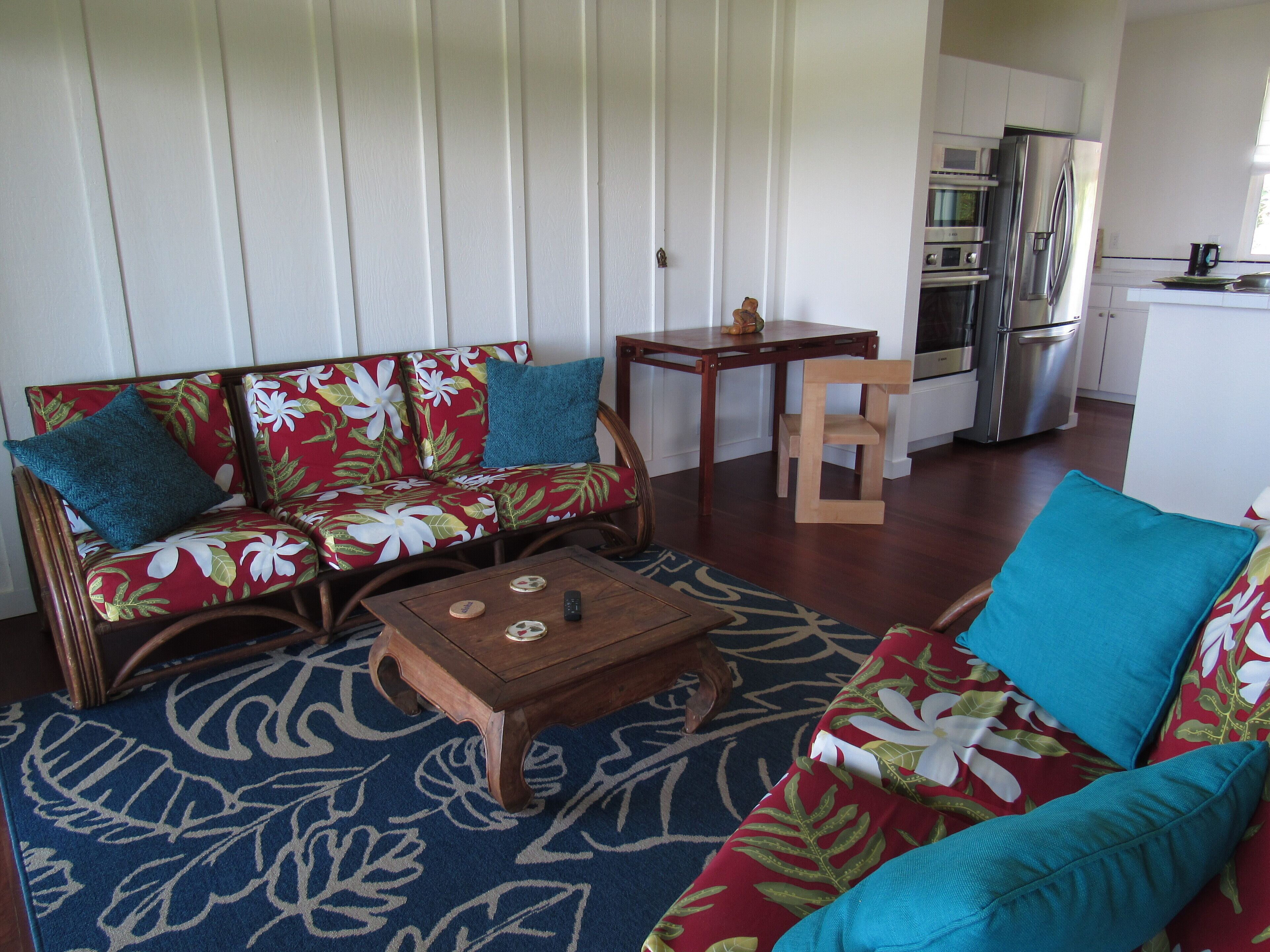 Ein Wohnzimmer mit einer Couch, einem Holztisch und einem kleinen Holzstuhl.