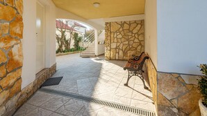 A covered outdoor area with stone walls, a bench, and a staircase leading to an upper level. - Beautiful apartment in Nin with WiFi (Nin)