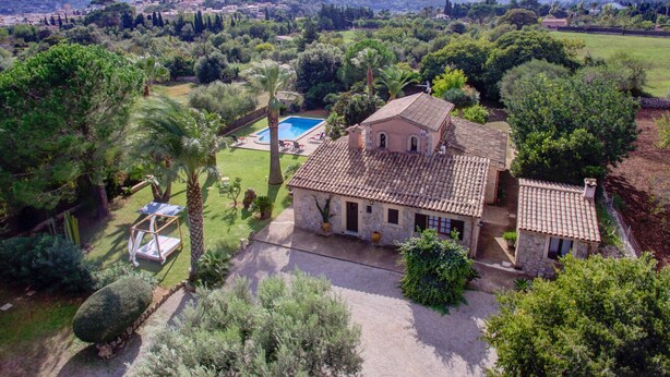 An aerial view of a villa with a swimming pool, surrounded by lush greenery and mountains in the background. - Villa Joanna (Pollença)