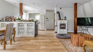 Une cuisine spacieuse dotée d’un plancher en bois, d’un îlot central avec des portes en verre et d’une cuisinière intégrée.