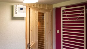 Eine Holztür mit Thermostat und einem roten Heizkörper.