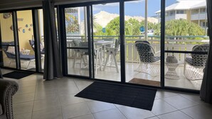 Habitación de hotel con balcón, zona de comedor y vistas de los edificios y zonas verdes circundantes.