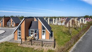 A row of modern, single-story houses with large windows and a flat roof, arranged in a residential area with a clear sky. - 2 bedroom nice home in Hadsund (Hadsund)