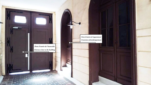 Une entrée d’immeuble avec une porte d’entrée principale et une porte d’entrée donnant accès à l’immeuble.