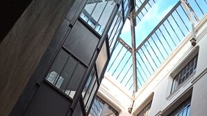 Un immeuble à plusieurs étages doté de grandes fenêtres et d’une cour intérieure.