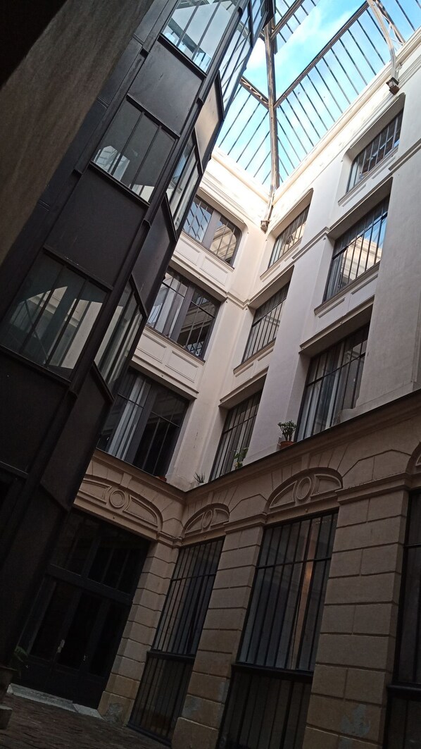 Un edificio de varios pisos con amplios ventanales y un patio central.