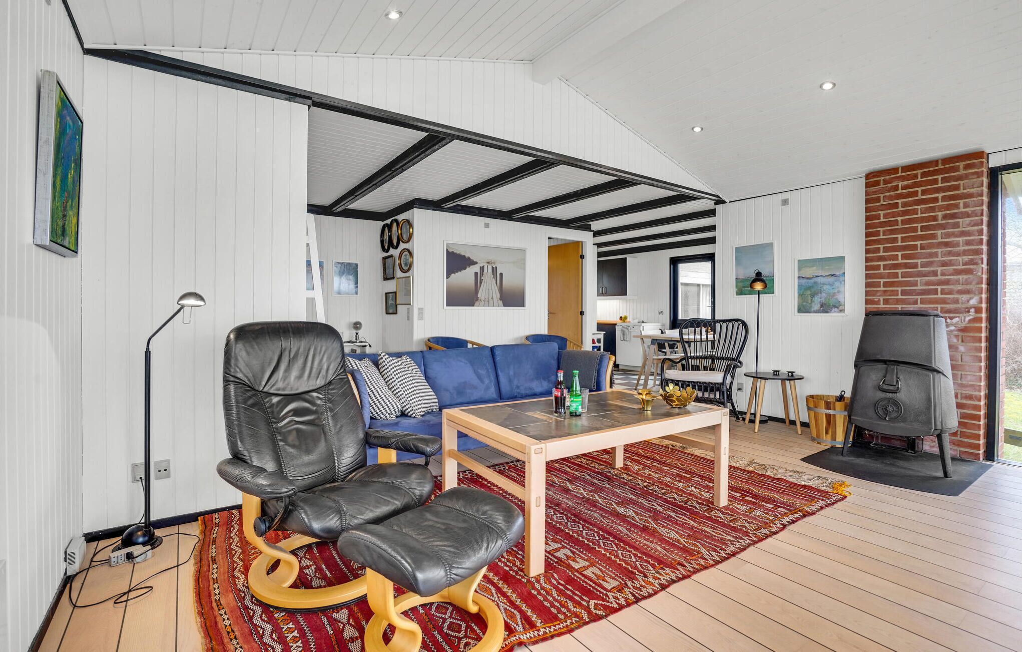 Un salon moderne avec un fauteuil en cuir, un canapé bleu et une table à manger.