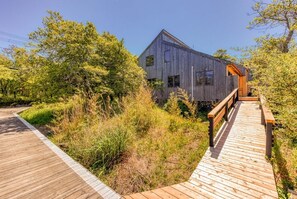 A modern wooden building with a wooden deck leading to it.