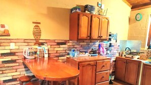 Una cocina con encimera de madera, taburetes y salpicadero de pared de ladrillo.