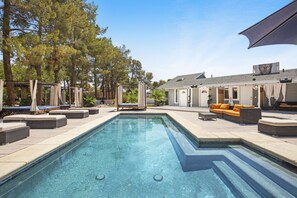 A swimming pool with lounge chairs and a covered seating area. - Your Own Resort Close to the Strip (Las Vegas)