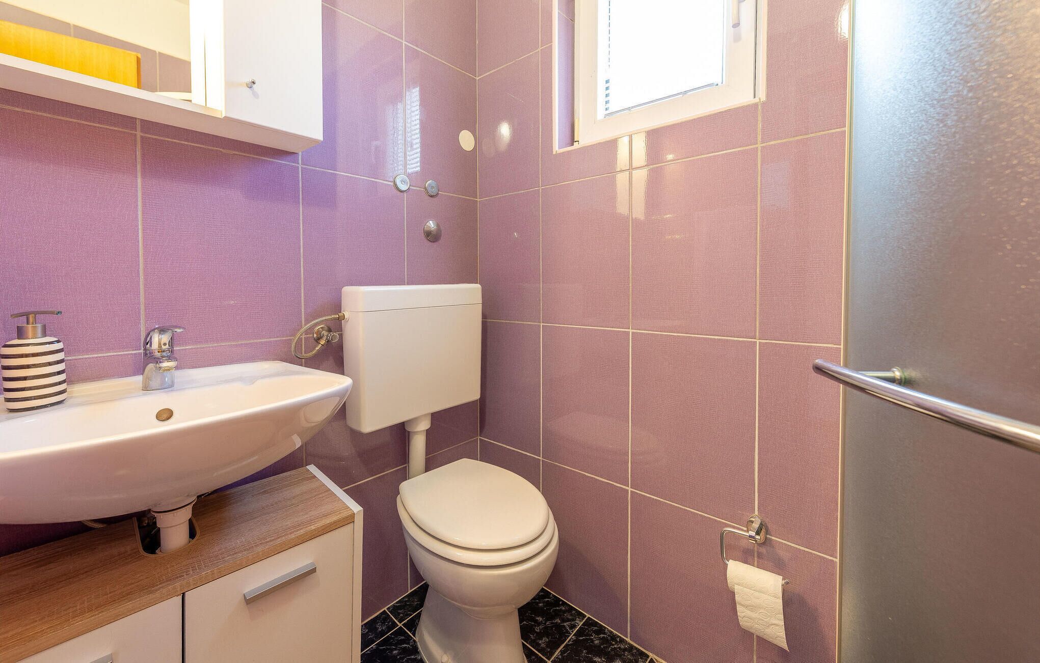 A bathroom with a white sink, a toilet, and a mirror.
