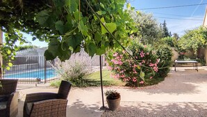 Un jardin avec une piscine, du mobilier d’extérieur et une variété de plantes.