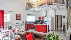 Un appartement moderne doté d’un coin repas, d’une cuisine et d’un balcon avec vue.