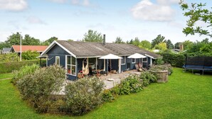 A house with a patio area, a hot tub, and a trampoline in the yard. - Lovely home in Juelsminde with kitchen (Juelsminde)