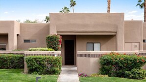 A modern building with a beige facade, a central entrance, and a well-maintained lawn. - LUXURY mid century modern Palm Springs/Golf cart & bicycles/best view (Cathedral City)