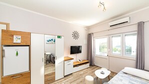 Een moderne hotelkamer met een bed, een tafeltje, een televisie en een kledingkast.