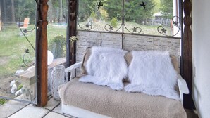Un espace extérieur accueillant, avec un mur en pierre et une porte vitrée donnant sur un jardin.