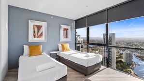 A modern hotel room with two beds, large windows, and city views. - Circle on Cavill Ocean View  Surfers Paradise (Surfers Paradise)
