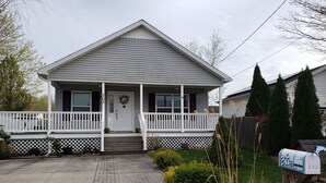 Einbungalow mit Veranda, Briefkasten und Sicherheitsschild.