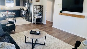 Un salon moderne avec un canapé, une table basse et un téléviseur fixé au mur.