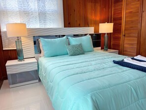 A bedroom with a bed, two bedside tables, and a nightstand.