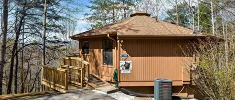 A small wooden cabin with a wooden deck and a sign indicating it is a bear viewing area.