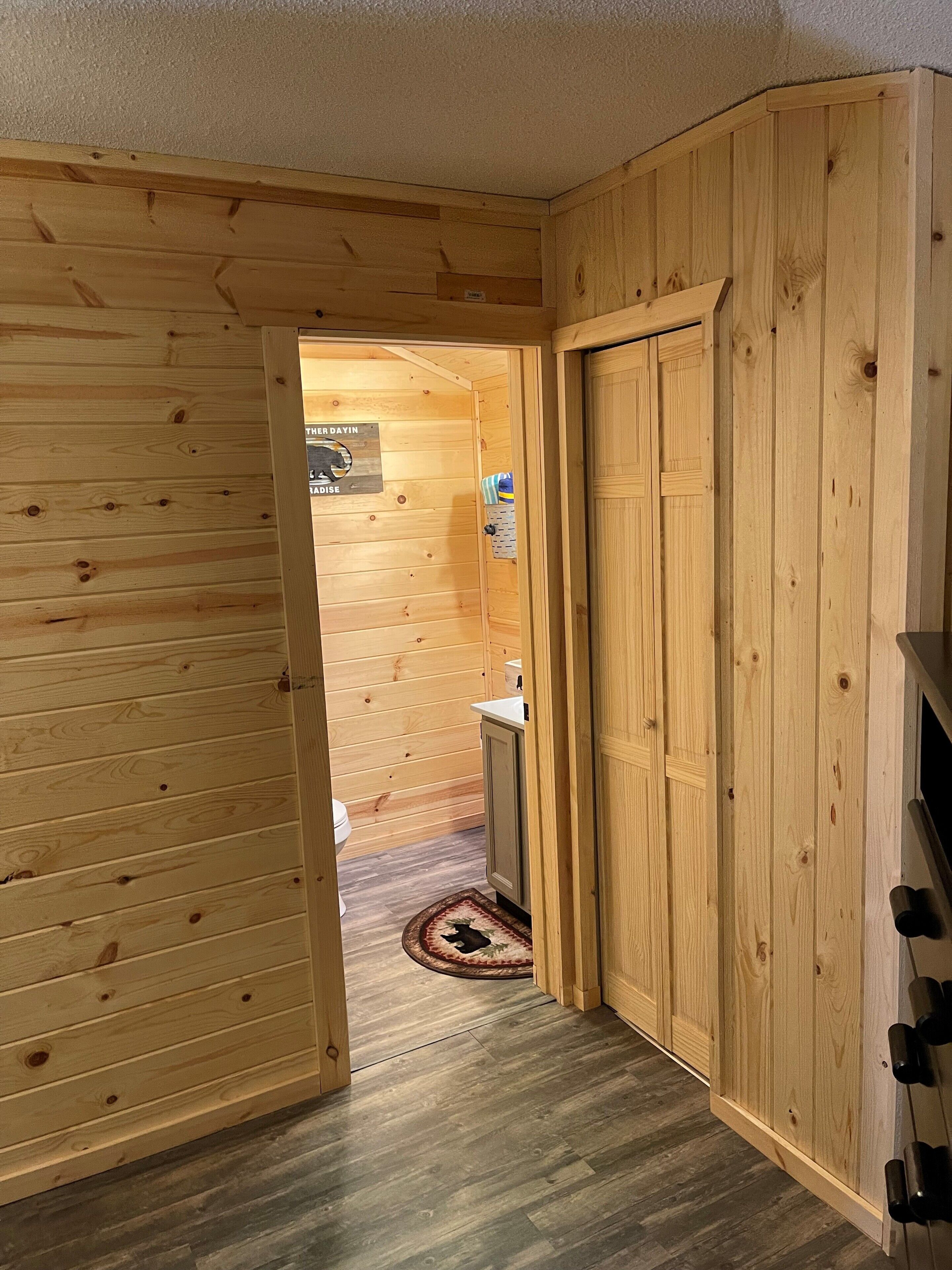 A wooden interior with a door leading to a bathroom.