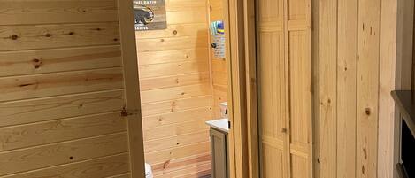 A wooden interior with a door leading to a bathroom.
