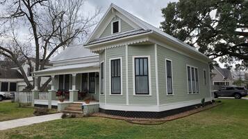 A single-story house with a porch, a covered entryway, and a front yard.