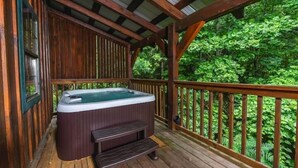A wooden deck with a hot tub and a bench. - Moonshine Holler (Sevierville)