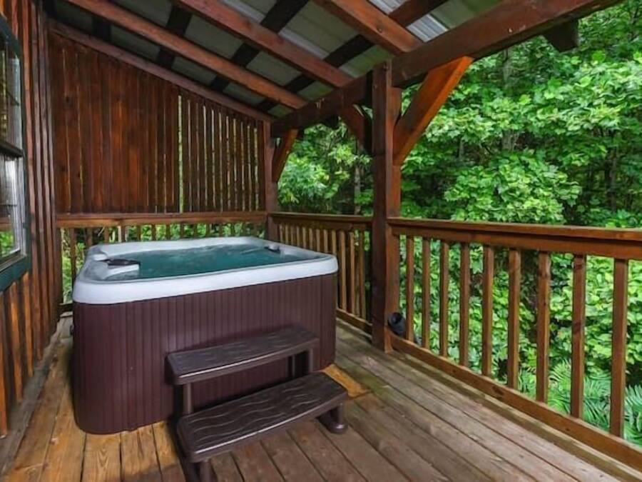Una terraza de madera con un jacuzzi y un banco.