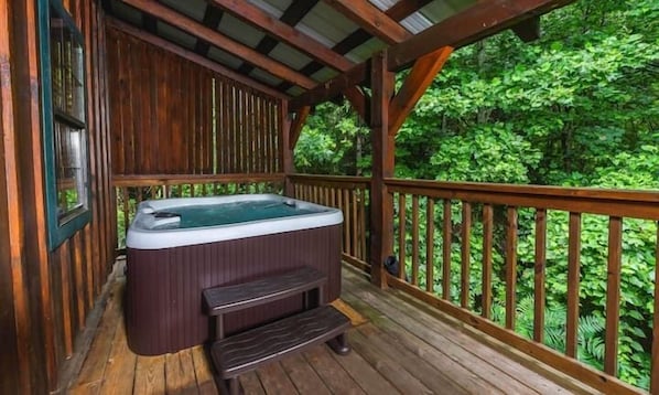 A wooden deck with a hot tub and a bench. - Moonshine Holler (Sevierville)