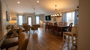 A spacious living area with a dining table, chairs, a sofa, and a television. - Charming Beach Cottage, Beach Chair Service Included. Snowbirds special rates! (Miramar Beach)