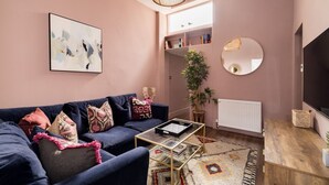 A living room with a sofa, coffee table, and a large mirror.