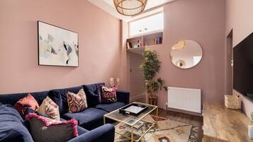 A living room with a sofa, coffee table, and a large mirror.