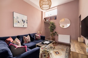 Un salon avec un canapé, une table basse et un grand miroir.