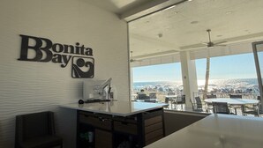 Un intérieur moderne, avec une enseigne indiquant « Bonita Bay », un ventilateur de plafond et une vue sur la plage.